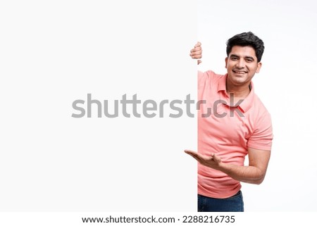 Young indian man showing and pointing of big white board with copy space