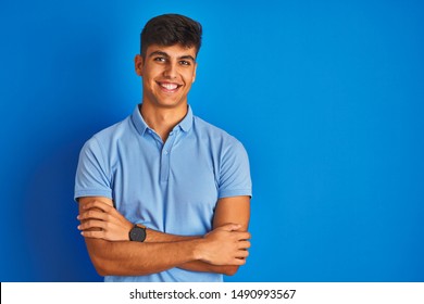 Young Indian Man Wearing Casual Polo Standing Over Isolated Blue Background Happy Face Smiling With Crossed Arms Looking At The Camera. Positive Person.