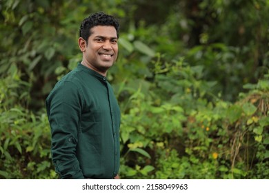 

Young Indian man wearing green shirt standing over green background smiling and looking at the camera  - Shutterstock ID 2158049963