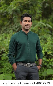 

Young Indian man wearing green shirt standing over green background smiling and looking at the camera  - Shutterstock ID 2158049973