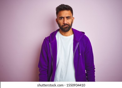Young Indian Man Wearing Purple Sweatshirt Standing Over Isolated Pink Background Depressed And Worry For Distress, Crying Angry And Afraid. Sad Expression.