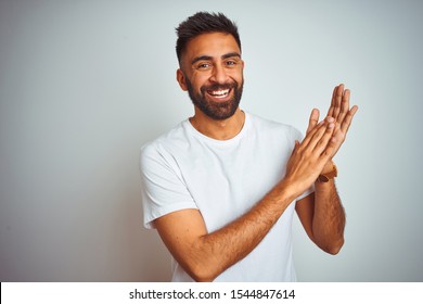 Young Indian Man Wearing T-shirt Standing Over Isolated White Background Clapping And Applauding Happy And Joyful, Smiling Proud Hands Together