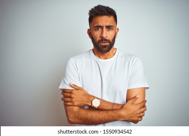 Young Indian Man Wearing T-shirt Standing Over Isolated White Background Shaking And Freezing For Winter Cold With Sad And Shock Expression On Face