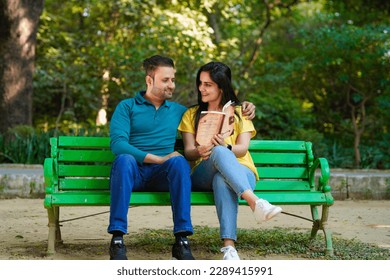 Young indian man and woman reading book at park. - Powered by Shutterstock