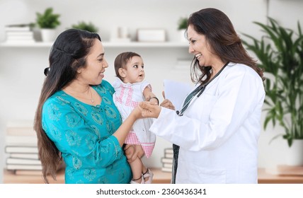 Young indian mother with her cute little baby visiting general pediatrician in modern clinic for routine check-up, Healthcare and medical concept. - Powered by Shutterstock