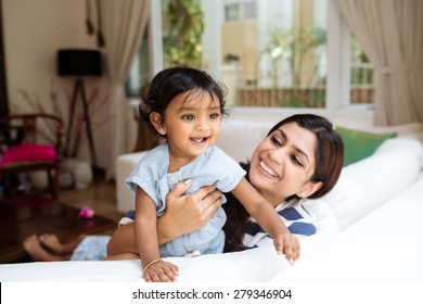 Young Indian Mother And Her Little Daughter Having Fun At Home