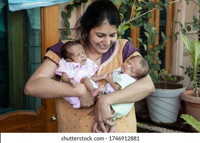 Young Indian Mother Holding Her Two Cute Adorable Newborn Twin Babies Right After Delivery, Single Parent, Motherhood Concept. 