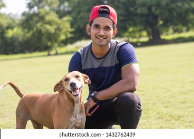 Young Indian Sports Man Playing With Dog In Sports Ground While Jogging. Male  Sports And Fitness Concept.