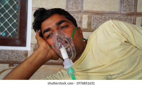 Young Indian Taking Emergency Oxygen With Cannula Outside Of Hospital. Severe Causes Due To Covid In India Concept