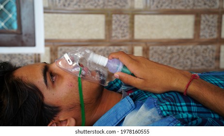 Young Indian Taking Emergency Oxygen With Cannula Outside Of Hospital. Severe Causes Due To Covid In India Concept