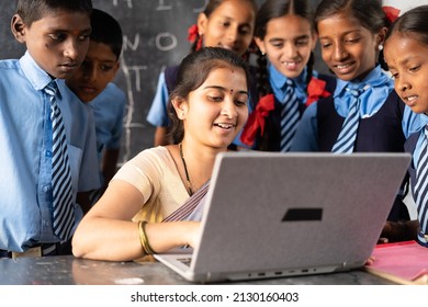 Young Indian Teacher Teaching On Laptop With School Uniform Students At Classroom - Concept Of Development, Technology And Digital Education