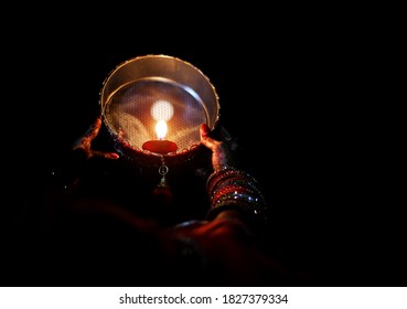 Young Indian woman celebrating Karva Chauth at night. Karva Chauth is a one-day festival celebrated by Hindu women four days after purnima (a full moon) in the month of Kartika. 