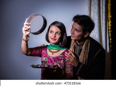 Young Indian woman celebrating Karwa chauth festival with husband