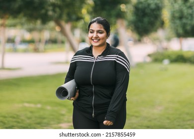 A Young Indian Woman Holding A Yoga Mat Returns After Doing Yoga Or Fitness Outdoors