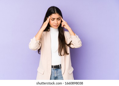 Young indian woman isolated on purple background touching temples and having headache.