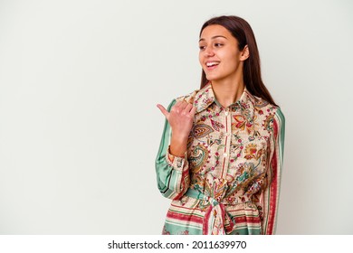 Young Indian woman isolated on white background points with thumb finger away, laughing and carefree.