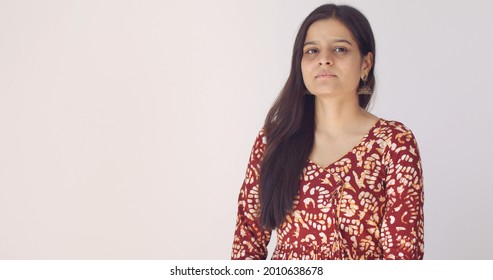 A Young Indian Woman With Long Brown Hair And A Serious Facial Expression