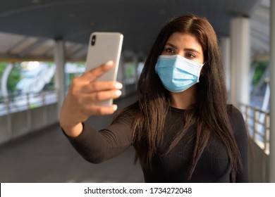 Young Indian Woman With Mask Taking Selfie At The Footbridge