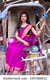 Young Indian Woman Sitting In A Tricycle Taxi ( Rickshaw) In A Local Market In Kolkata, India.