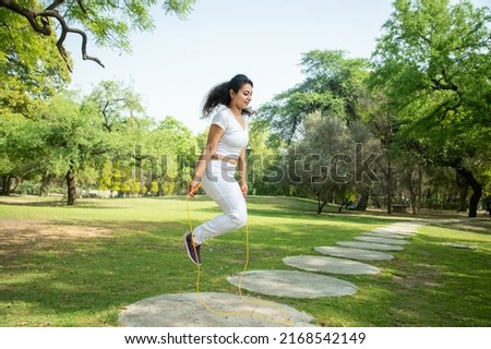 Young indian woman skipping rope at Summer park , Asian female do Jumping exercise or workout outdoor, Fitness and health. hobby Fun activity. Copy space, 