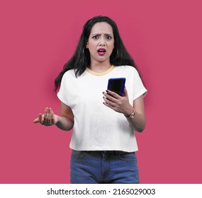 Young Indian Woman Or South Asian Girl Looking At Camera Happy, Angry, Shocked, Annoyed Expression Isolated Over Pink Background. Advertisement Concept.