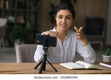 Young Indian Woman Speaker Or Coach Record Live Video Broadcast On Cellphone Camera On Tripod. Successful Ethnic Female Teacher Or Trainer Talk On Webcam, Have Online Call Or Webinar On Cell.