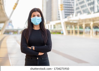 Young Indian Woman Wearing Mask With Arms Crossed At The Skywalk Bridge