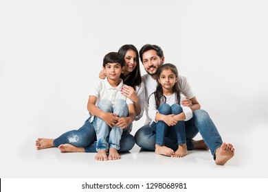 Young Indian/asian Family Sitting Isolated Over White Background. Selective Focus