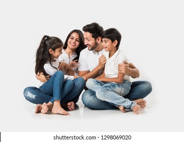 Young Indian/asian family sitting isolated over white background. selective focus
