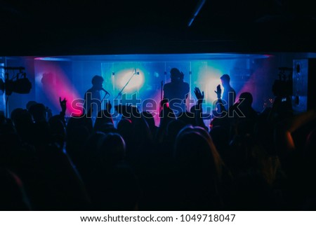 Young indie band performs on stage at the club