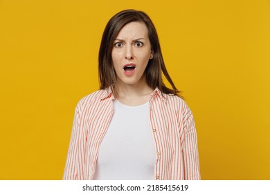 Young indignant sad irritated outraged angry woman she 30s wears striped shirt white t-shirt look camera with opened mouth isolated on plain yellow background studio portrait. People lifestyle concept