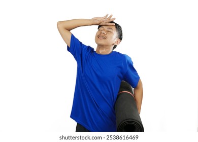 Young Indonesian man in blue shirt tired while exercising while carrying exercise mat, concept of healthy lifestyle with sufficient exercise, isolated on white background. - Powered by Shutterstock