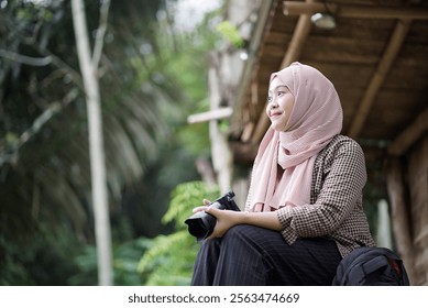 young Indonesian woman in hijab taking nature scenery photo from forest cabin, travel concept. - Powered by Shutterstock