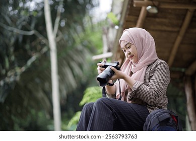 young Indonesian woman in hijab taking nature scenery photo from forest cabin, travel concept. - Powered by Shutterstock