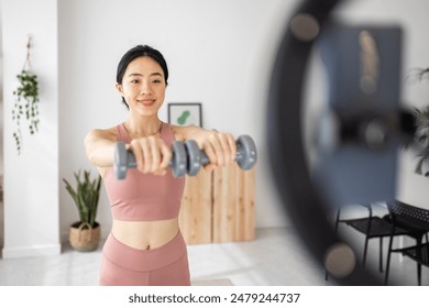 Young influencer asian woman recording fitness video tutorials for social media network at home. - Powered by Shutterstock