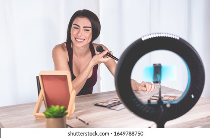 Young Influencer Woman Creating Social Media Videos With Smartphone While Putting On Make Up - New Digital Jobs Trends, Technology, Cosmetics And Fashion Concept - Focus On Her Face