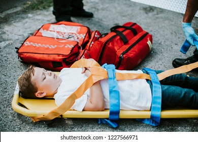 Young injured boy lying on an ambulance stretcher - Powered by Shutterstock