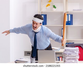 Young injured male employee working in the office