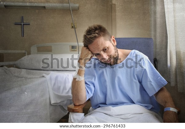 young\
injured man in hospital room sitting alone in pain looking negative\
and worried for his bad health condition sitting on chair suffering\
depression on a sad lonely medical\
background