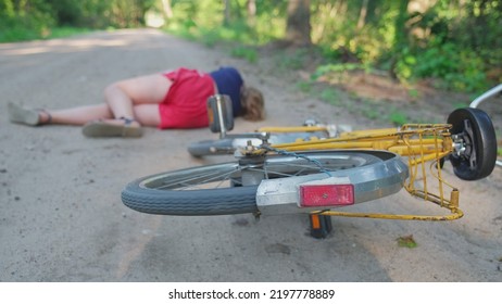 Young Injured Unconscious Caucasian Girl Cyclist Laying On Ground Rural Road After Being Hit By Car