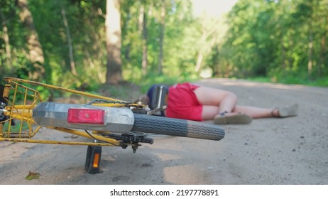 Young Injured Unconscious Caucasian Girl Cyclist Laying On Ground Rural Road After Being Hit By Car