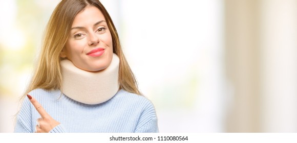 Young injured woman wearing neck brace collar pointing away side with finger