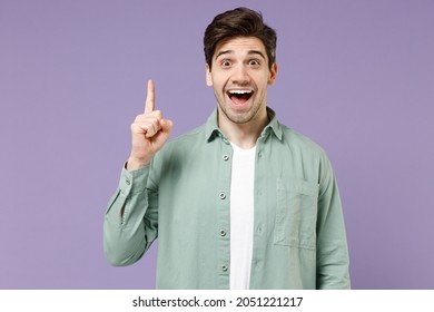 Young insighted smart proactive caucasian man 20s wearing mint shirt white t-shirt holding index finger up with great new idea isolated on purple background studio portrait. People lifestyle concept. - Shutterstock ID 2051221217