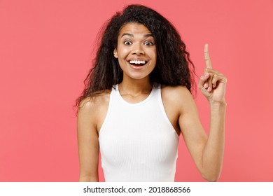 Young insighted smart proactive fun african american woman 20s wearing casual white tank shirt holding index finger up with great new idea isolated on pink color background. People lifestyle concept.