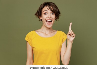 Young Insighted Smart Proactive Woman She 20s Wear Yellow T-shirt Holding Index Finger Up With Great New Idea Isolated On Plain Olive Green Khaki Background Studio Portrait. People Lifestyle Concept