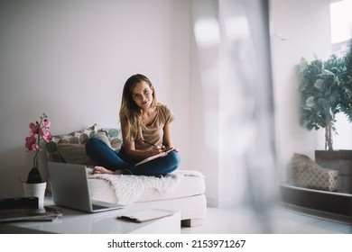 Young intelligent student doing education homework during exam preparation in home apartment, portrait of clever Caucasian hipster girl holding personal notepad planning project organisation