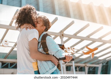 Young international couple meeting at airport departures area with luggage, happy hugging each other, saying good bye before vacation or business trip - Powered by Shutterstock