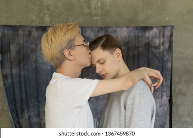 Young International Homosexuals Gay Couple Love Each Other, Hugging And Kissing Isolated Over Grey Background. People, Homosexuality, Gay Relationships Concept