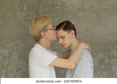 Young International Homosexuals Gay Couple Love Each Other, Hugging And Kissing Isolated Over Grey Background. People, Homosexuality, Gay Relationships Concept