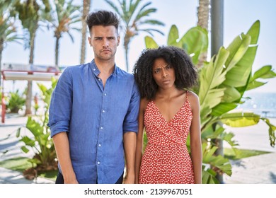 Young Interracial Couple Outdoors On A Sunny Day Skeptic And Nervous, Frowning Upset Because Of Problem. Negative Person. 